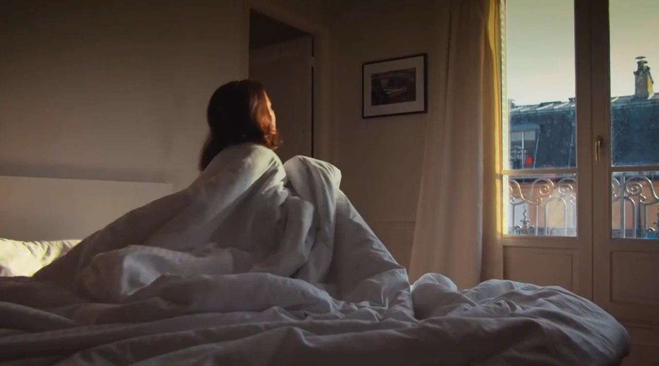 Endor film still: a woman waking by a window, "Check-in and re-connect"