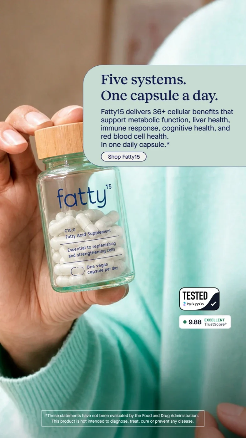 fatty15: a hand holding the glass supplement bottle against teal fabric